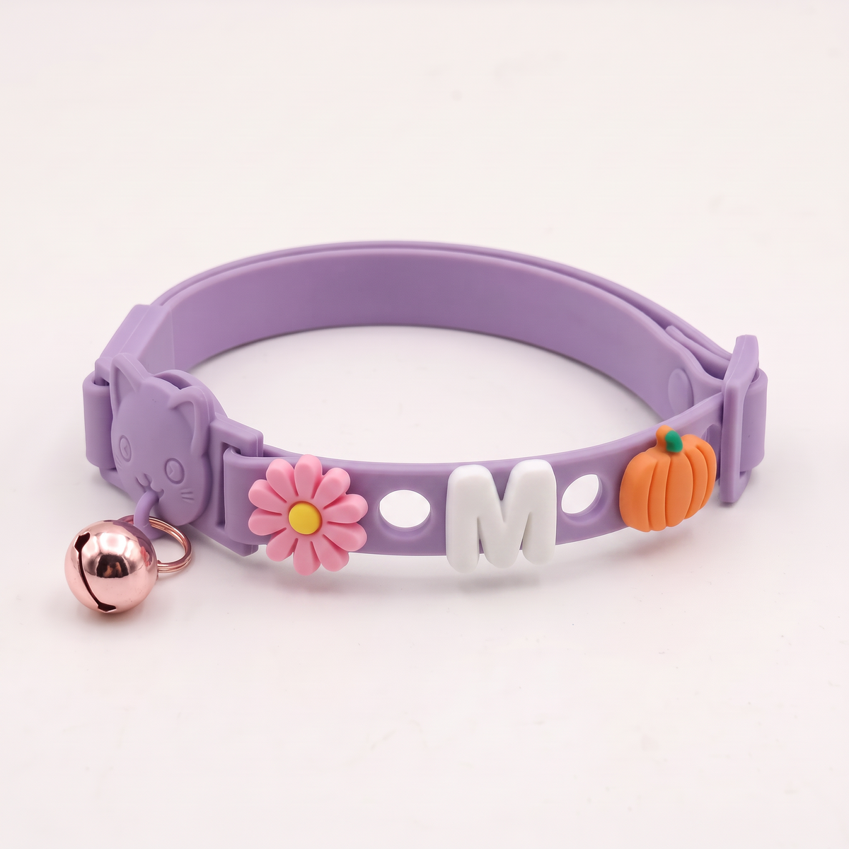 Lavender cat collar with daisy, letter M and pumpkin charms on a white background